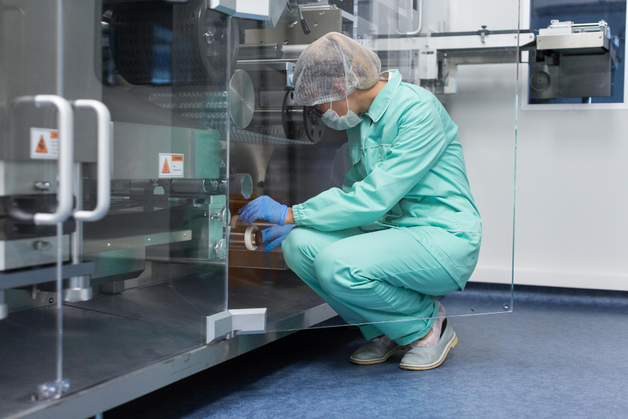 jakość w zakładach produkcyjnych (kobieta w stroju laboratoryjnym)