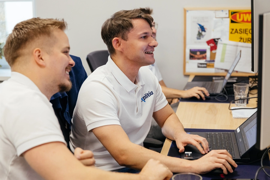 transformacja cyfrowa przykłady (dwóch mężczyzn z zespołu explitia siedzi przed monitorami)