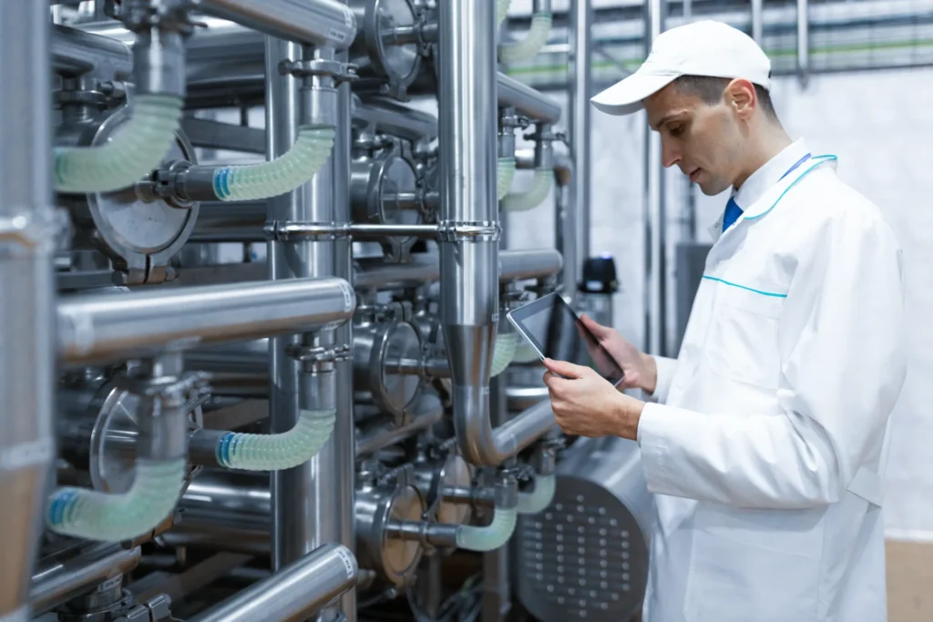 EMS implementation – what should you do before sending an RFQ?
(photo of a dairy plant employee holding a tablet next to a machine)
